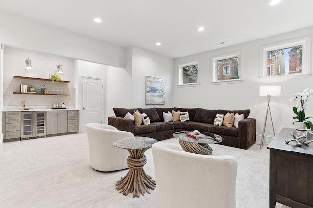 living area featuring beverage cooler, indoor wet bar, recessed lighting, and light colored carpet