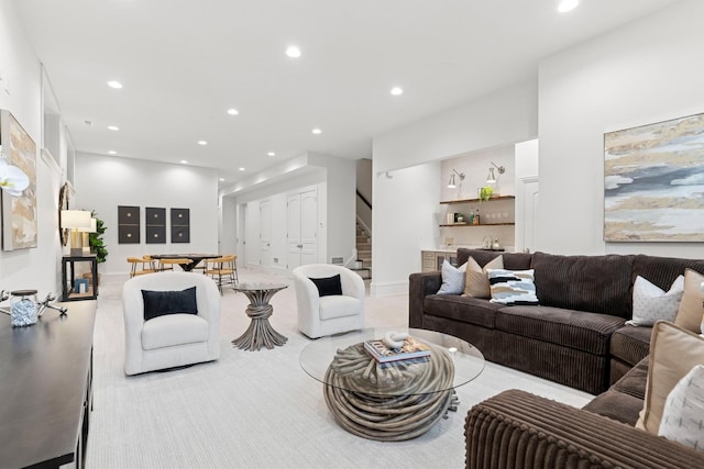 living area featuring stairs, baseboards, and recessed lighting