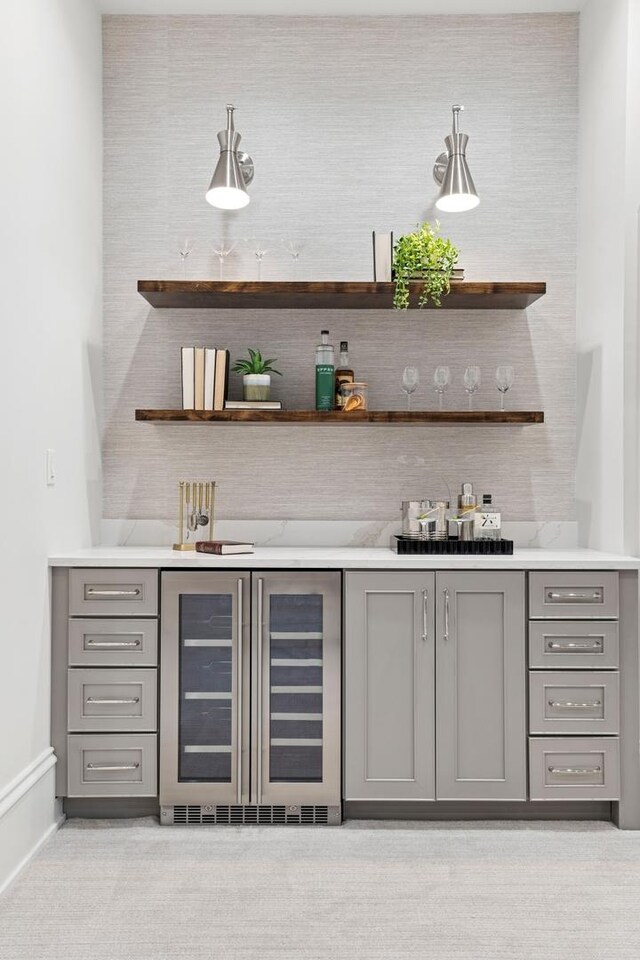 bar with baseboards, bar, and beverage cooler