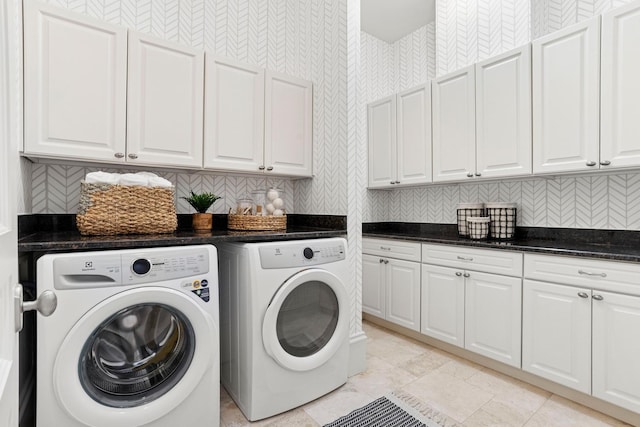 clothes washing area with cabinet space and washer and clothes dryer