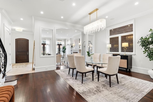 dining room with recessed lighting, hardwood / wood-style floors, ornamental molding, baseboards, and arched walkways
