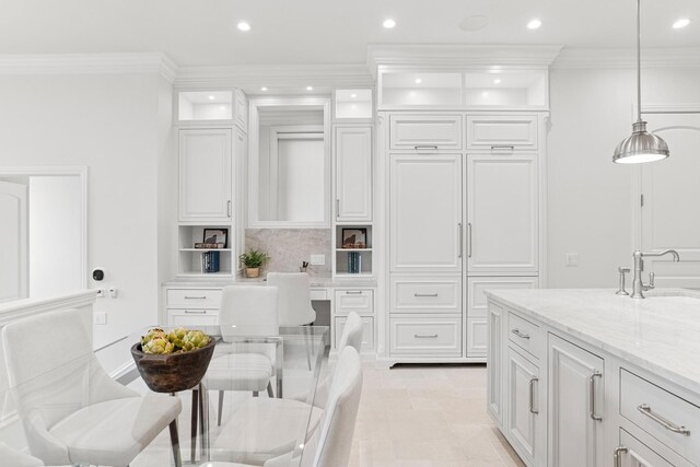 kitchen featuring light stone countertops, recessed lighting, glass insert cabinets, white cabinetry, and a sink