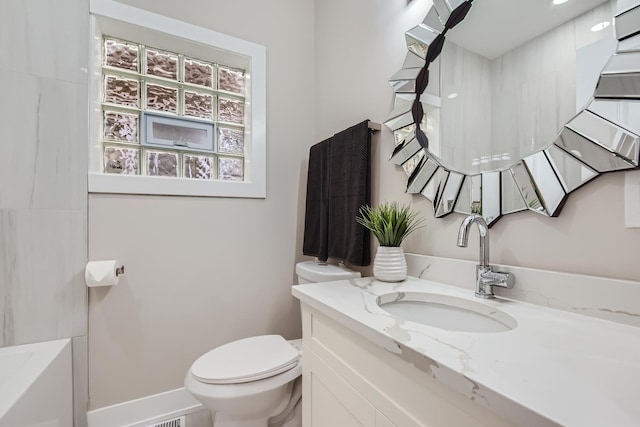 full bath with baseboards, toilet, and vanity