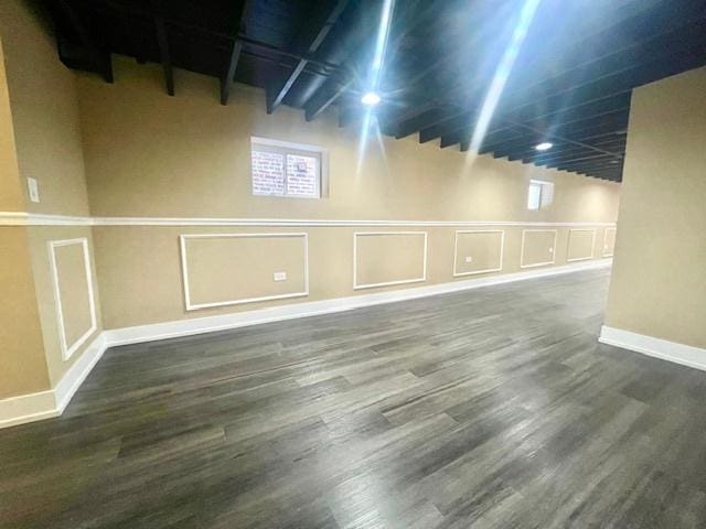 basement featuring wood finished floors and a decorative wall