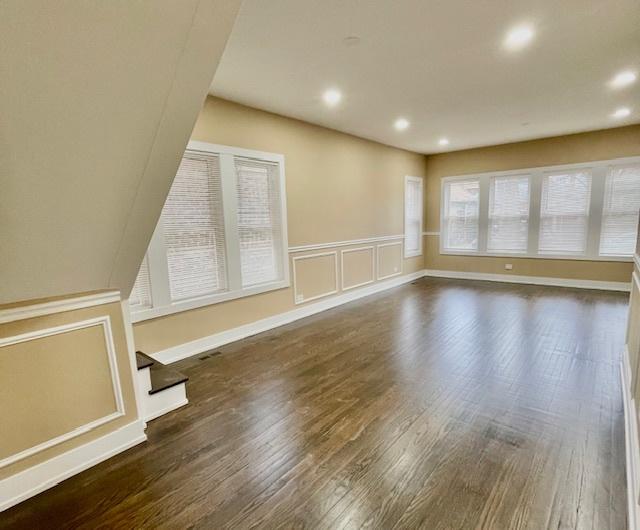 empty room with a decorative wall, dark wood-type flooring, and recessed lighting