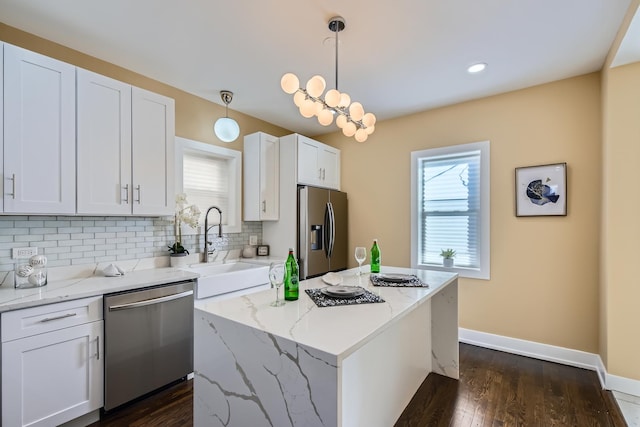 kitchen featuring a sink, white cabinetry, tasteful backsplash, dark wood-style floors, and stainless steel appliances