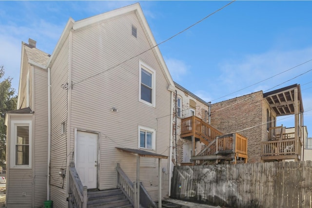 rear view of property with fence and entry steps
