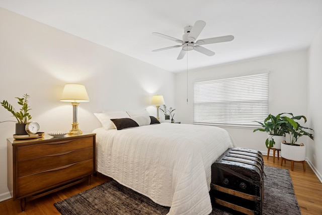 bedroom featuring wood finished floors, baseboards, and ceiling fan