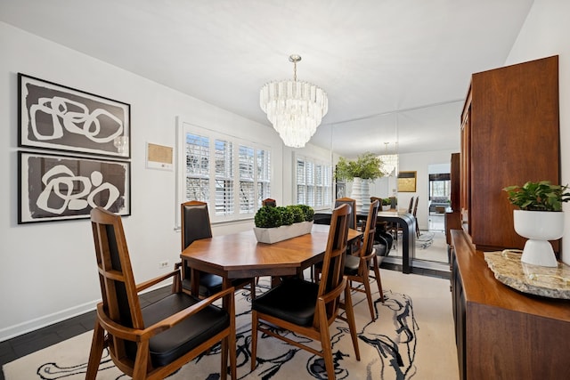 dining area featuring a chandelier and baseboards