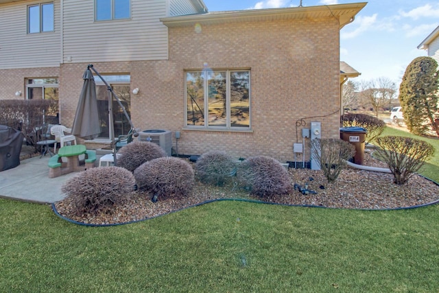11042 Quail Dr, Mokena, IL 60448 - back of property with a lawn, cooling unit, a patio, and brick siding