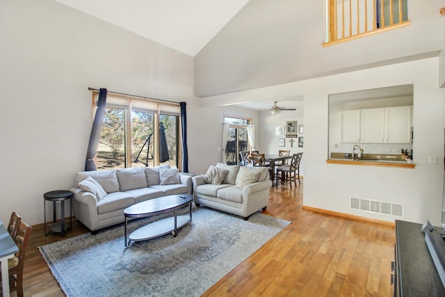 11042 Quail Dr, Mokena, IL 60448 - living room featuring high vaulted ceiling, light wood-style flooring, baseboards, visible vents, and ceiling fan