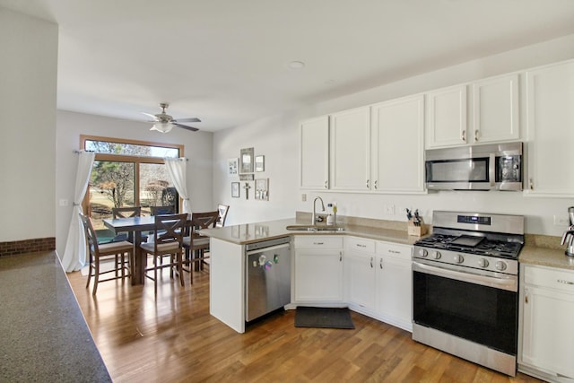 11042 Quail Dr, Mokena, IL 60448 - kitchen featuring light wood-style flooring, a sink, white cabinets, a peninsula, and appliances with stainless steel finishes
