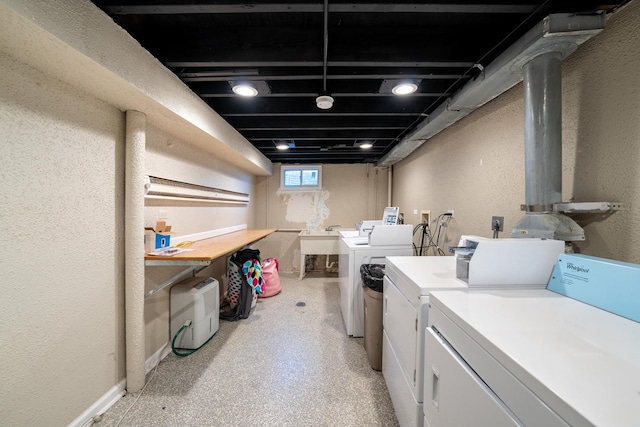 laundry room featuring a textured wall and washer and dryer