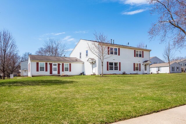 back of property with a lawn and central AC
