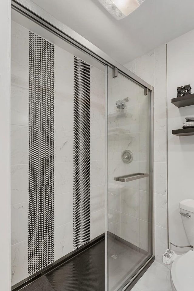 full bath featuring a stall shower and toilet