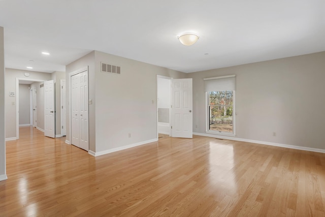 empty room with recessed lighting, baseboards, light wood finished floors, and visible vents