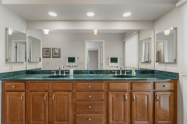 bathroom featuring double vanity, a sink, and recessed lighting