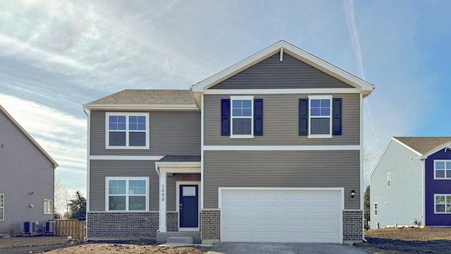 view of front facade with a garage, brick siding, and aphalt driveway