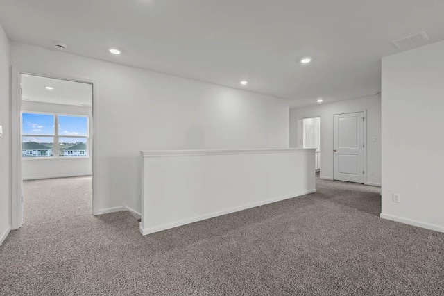 carpeted empty room featuring visible vents, baseboards, and recessed lighting