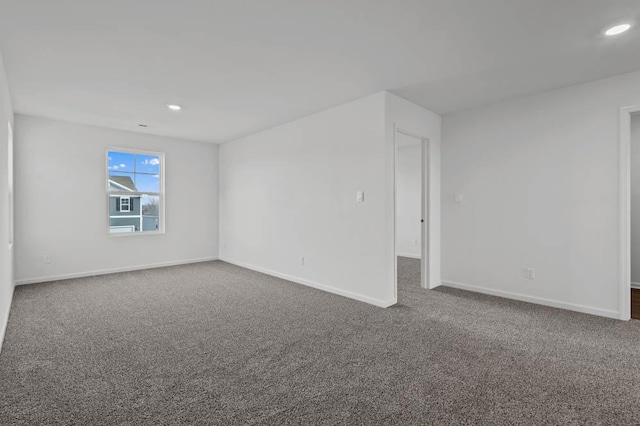 carpeted spare room featuring baseboards and recessed lighting