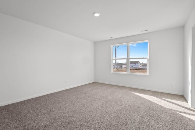 unfurnished room featuring carpet floors and baseboards