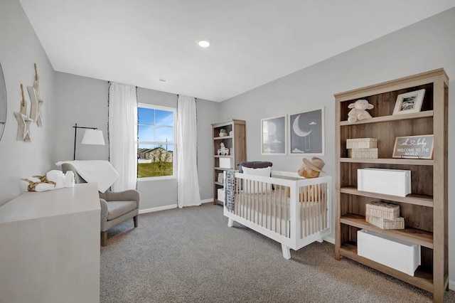 bedroom featuring baseboards, a crib, and carpet floors