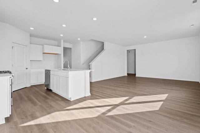 kitchen featuring open floor plan, white cabinets, light wood finished floors, and visible vents