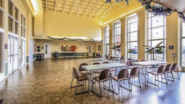 dining space featuring baseboards, a towering ceiling, and french doors