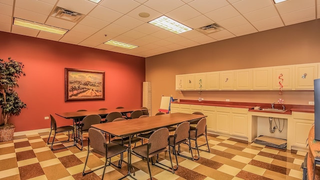 dining room featuring visible vents, light floors, and a paneled ceiling