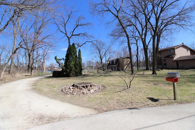 exterior space with dirt driveway and an outdoor fire pit