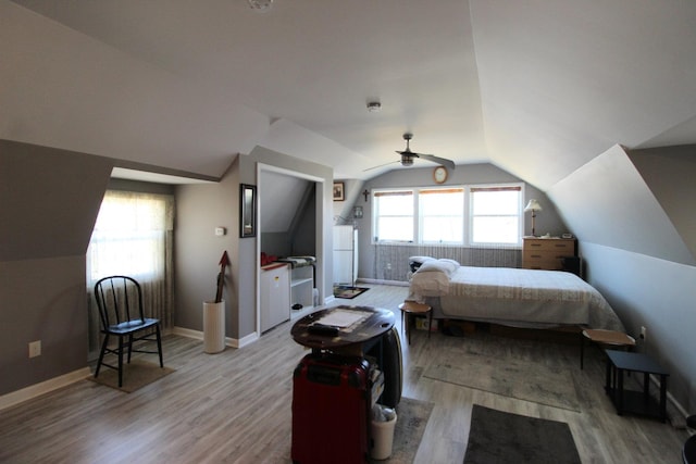 bedroom featuring baseboards, light wood-style floors, lofted ceiling, and ceiling fan