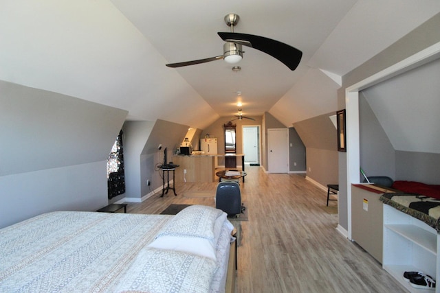 bedroom featuring vaulted ceiling, baseboards, and light wood finished floors