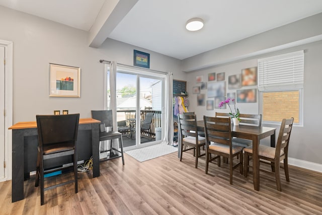 dining space featuring wood finished floors and baseboards