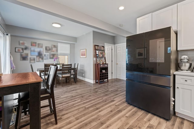 kitchen with white cabinetry, light wood-style flooring, baseboards, tasteful backsplash, and recessed lighting
