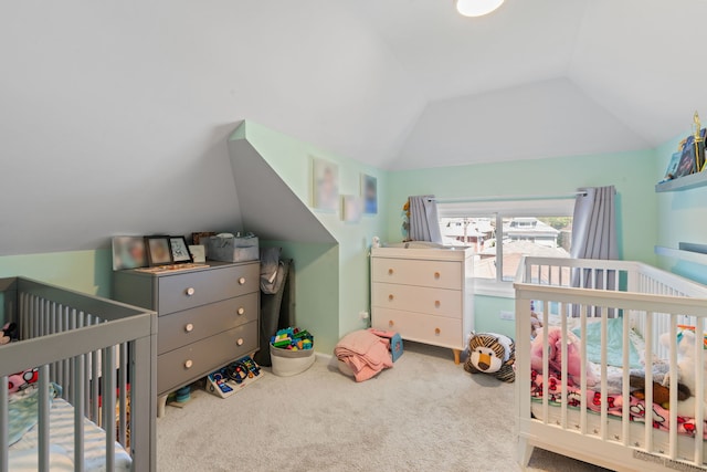 bedroom with lofted ceiling, carpet flooring, and a nursery area