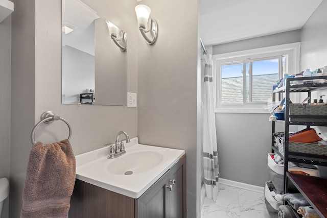 bathroom with marble finish floors, vanity, baseboards, and curtained shower