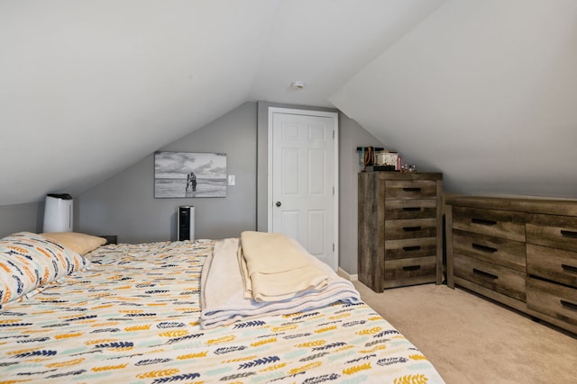 bedroom with light colored carpet and vaulted ceiling