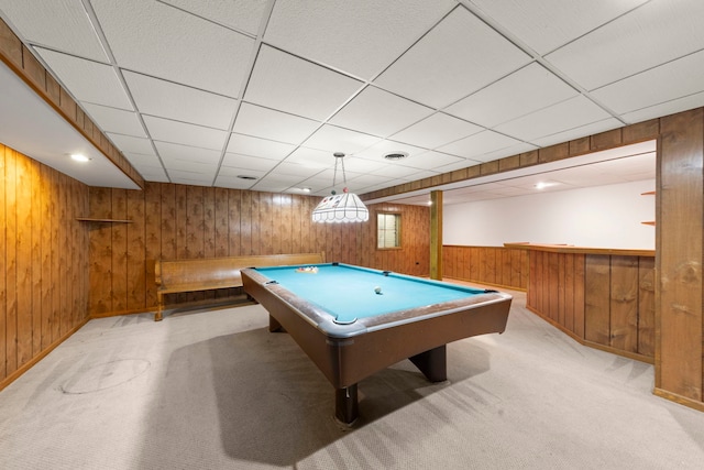 rec room with wooden walls, pool table, a drop ceiling, carpet, and baseboards