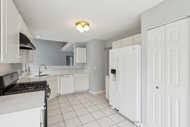 kitchen with a sink, light tile patterned floors, white cabinets, under cabinet range hood, and white appliances