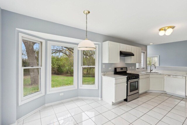 kitchen with white dishwasher, light countertops, under cabinet range hood, stainless steel range with gas stovetop, and a sink