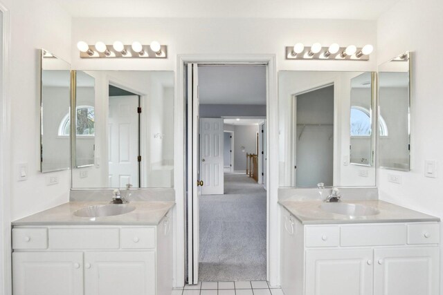 full bathroom with tile patterned floors, two vanities, and a sink