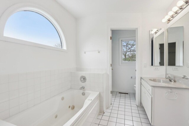 full bathroom featuring tile patterned flooring, vanity, toilet, and a jetted tub