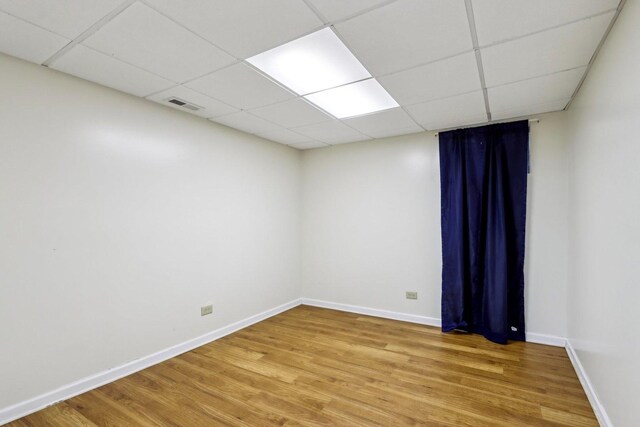 unfurnished room with baseboards, light wood-type flooring, and visible vents