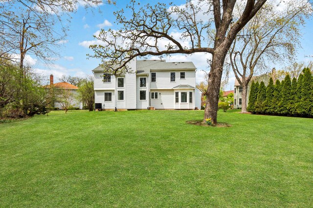 back of property with a lawn
