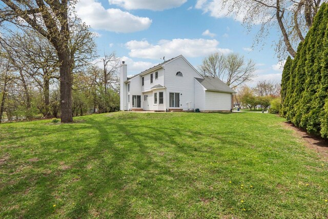 back of house with a yard, a chimney, and entry steps