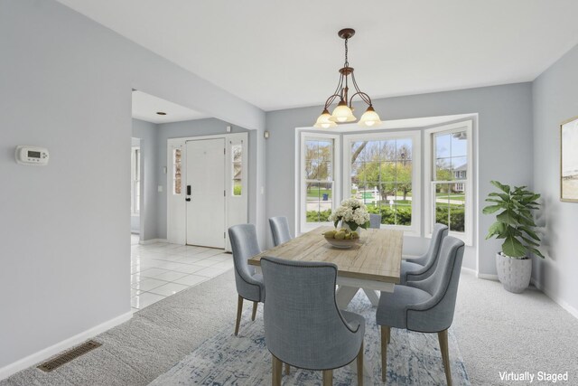 carpeted dining room with baseboards and visible vents