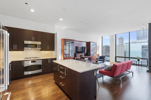 65 E Monroe St Unit 4315, Chicago, IL 60603 - kitchen featuring stainless steel appliances, dark wood-style floors, light countertops, open floor plan, and dark brown cabinets