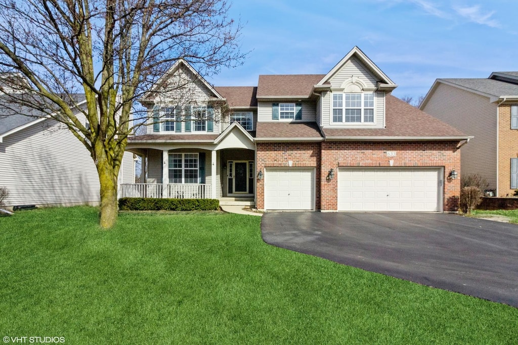 view of front of property featuring driveway, a front yard, covered porch, brick siding, and a garage
