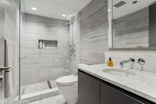 full bathroom featuring vanity, tile walls, toilet, a shower stall, and visible vents