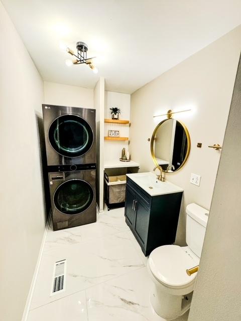 13110 W Playfield Dr, Crestwood, IL 60418 - bathroom featuring stacked washer / dryer, marble look tiles, and vanity